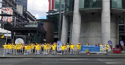 '图1:法轮功学员在奥克兰天空城炼功、讲真相。'