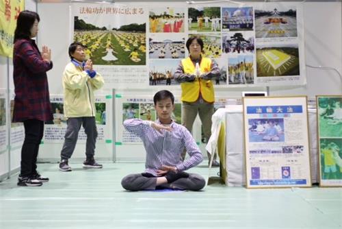 '图5~6:法轮功学员在第22届祖父江银杏黄叶节活动期间,在展位上炼功时'