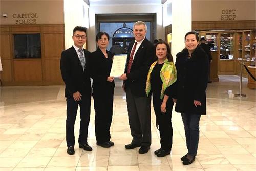 '图1:阿肯色州众议院决议的发起人、阿肯色州众议员丹尼尔·沙利文(Dan Sullivan,中)与法轮功学员合影。'