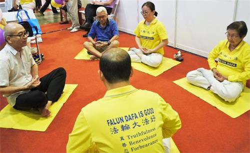 '图4：法轮功学员现场教不同族裔的人士炼静功。'