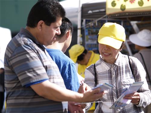 图6~8:中秋街会也吸引了不少各族裔的民众前来,他们有不少人在法轮功摊位前伫足了解真相。