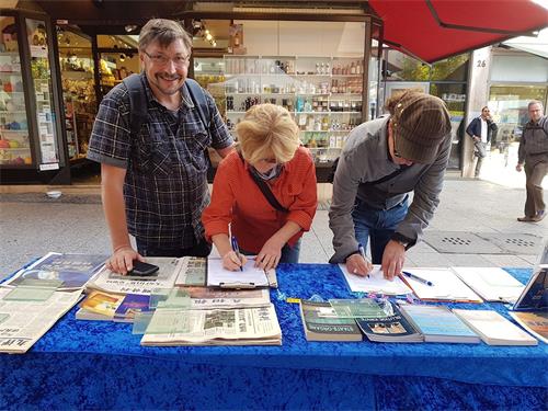 '图7:苏帕·理波桑(Sopa Libsang)先生和芭芭哈·鸿沃(Barbara Hoover)女士(左一和左二)在信息台前签名'