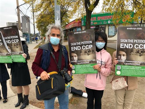 '图20：自伊朗的新移民科文（Koven）先生，站在展板前与退<span