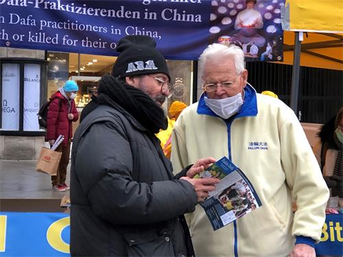 图7：一位路人认真聆听一位法轮功学员讲真相