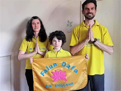 '图4:住在英格兰西南部德文郡乡村的法轮功学员凯特(Kat)和特雷弗(Trevor)与他们的儿子特里斯坦(Tristan)一家三口齐声恭祝:“慈悲伟大的师父生日快乐!”'