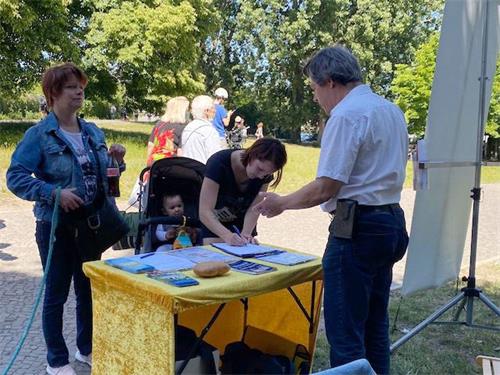 '图10：克里斯汀娜正在签字，支持法轮功学员反迫害'