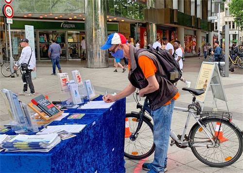 '图8~10:民众在反对活摘器官的请愿书上签名。'