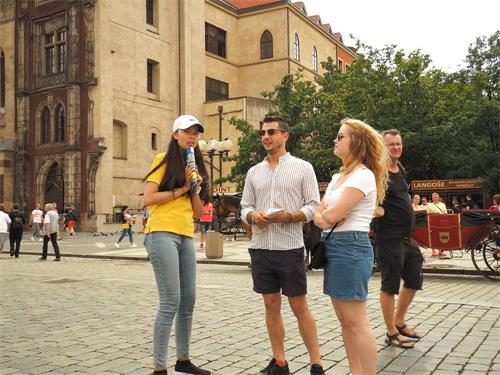 '图10:学员向民众讲述法轮功被酷刑迫害的真相'