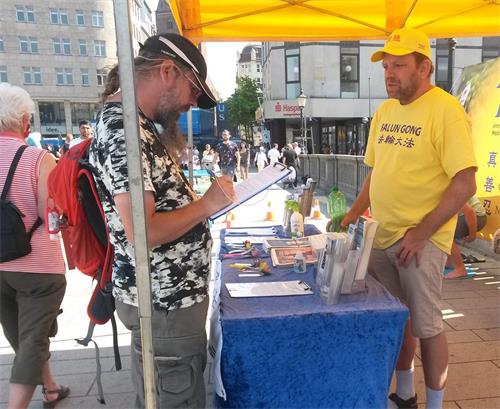 '图17:拉斯谴责中共对法轮大法的迫害,并为反迫害签了名。'