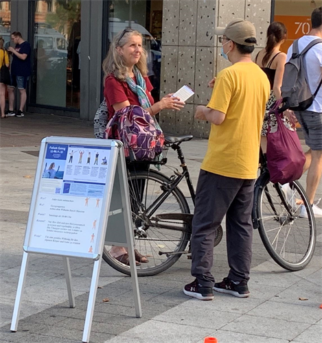 '图1~5:过往民众在法轮功学员摆出的信息展位前了解信息以及接过法轮功学员递出的真相传单'