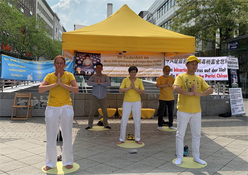 '图9:法轮功学员在向民众展示功法'