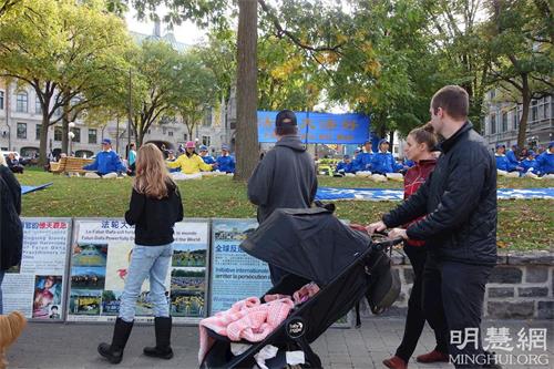 '图4～6：活动期间，许多人驻足，阅读法轮功学员递上的传单，浏览真相展板上的内容。'