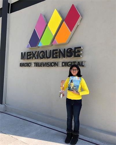 '图5:学员们也向电视台节目制作组的成员,赠送了法轮大法的介绍手册,以及法轮功学员手工制作的纸莲花。'