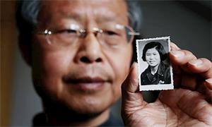 '张红兵手举母亲的照片(网络图片)'