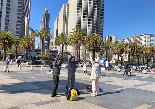 '图4:克里斯多夫(Christopher)和夏伦(Shannon)女士正在跟学员学法轮功的第二套功法——法轮桩法。'