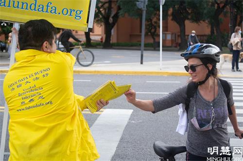 '图8~9:人们高兴的接、拿法轮功的真相资料。'