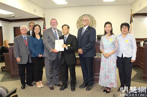 '图1:郡长和其他三位委员与法轮功学员合照。郡长小L.M.“马特”塞贝斯塔(前排左三)、美南法轮大法学会宋先生(左四)、斯泰西-亚当斯(Stacy Adams),第三选区委员 (左一)、大卫-林德(David Linder),第四选区委员(后排左一)、唐纳德-佩恩(Donald “Dude” Payne),第一选区委员(右三)'