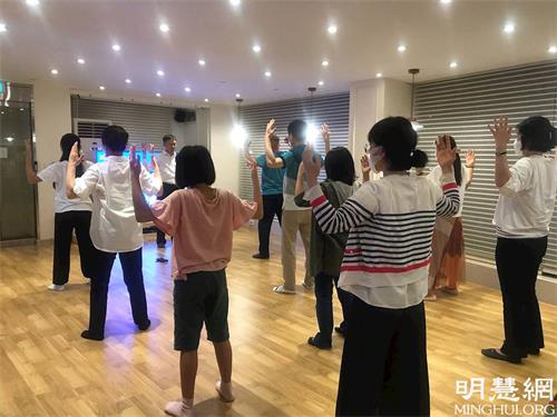 '图2:韩国首尔天梯书店法轮大法九天班(下午班)的学员正在学习法轮功炼功动作。'