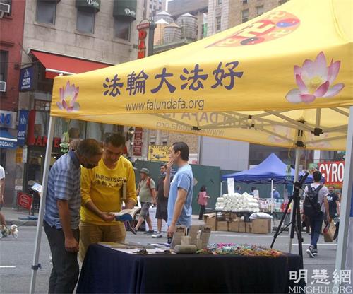 '图4:Salvatove Branciforte(左一)在听法轮功学员对法轮功书籍的介绍'