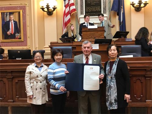图2:二零二二年三月八日,共和党议员约翰·阿沃利(John Avoli,右二)在州府大楼众议院会议厅为法轮功学员颁发决议案。(弗吉尼亚法轮功学员提供)