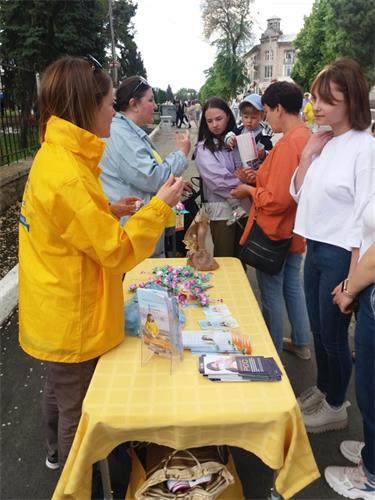 图10:法轮功学员向人们介绍法轮功的真相。