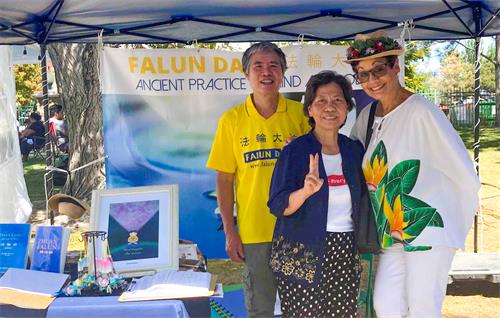 图1:二零二二年九月二日、三日和五日,犹他州法轮功学员在波利尼西亚文化遗产节日活动上设立展位,传播法轮功的真相,并征集支持“H.R. 6319——法轮功保护法”的签名。格温·安德森女士表示支持法轮功学员,并与学员合影。