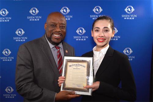 图16：二零二三年一月十四日，美国乔治亚州萨凡纳市市长范‧约翰逊（Van R. Johnson）在萨凡纳市民中心约翰尼·默瑟剧院（Johnny Mercer Theatre at Savannah Civic Center）向神韵巡回艺术团领舞演员周歌颁发褒奖。（大<span style='max-width:0px!important;margin-left:-4px;color:#eee!important;'>.</span>纪<span style='max-width:0px!important;margin-left:-4px;color:#eee!important;'>.</span>元<span style='max-width:0px!important;margin-left:-4px;color:#eee!important;'>;</span>）