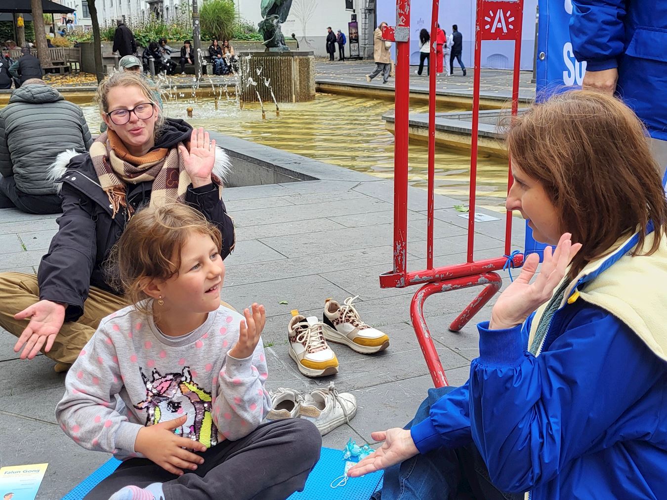 '图9:斯蒂芬妮和女儿活动现场学习打坐'