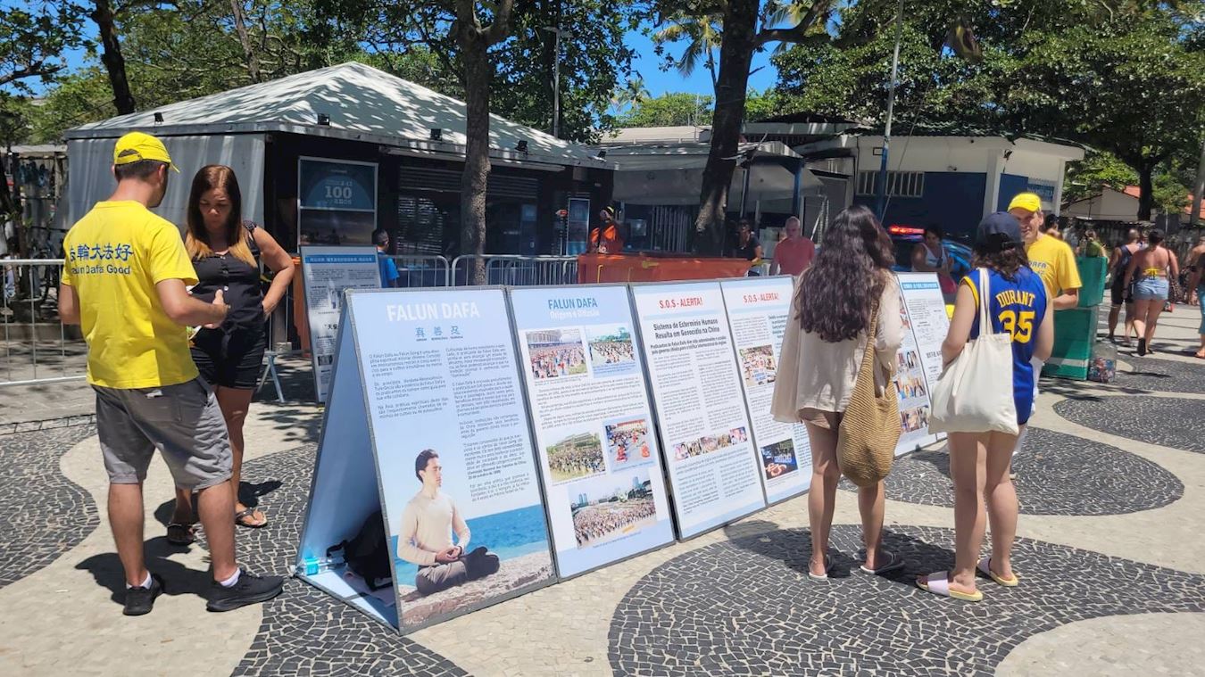 '图3~4:十一月十八日,科帕卡巴纳海滩,法轮功学员正在向民众讲述法轮大法在中国遭受的迫害。'