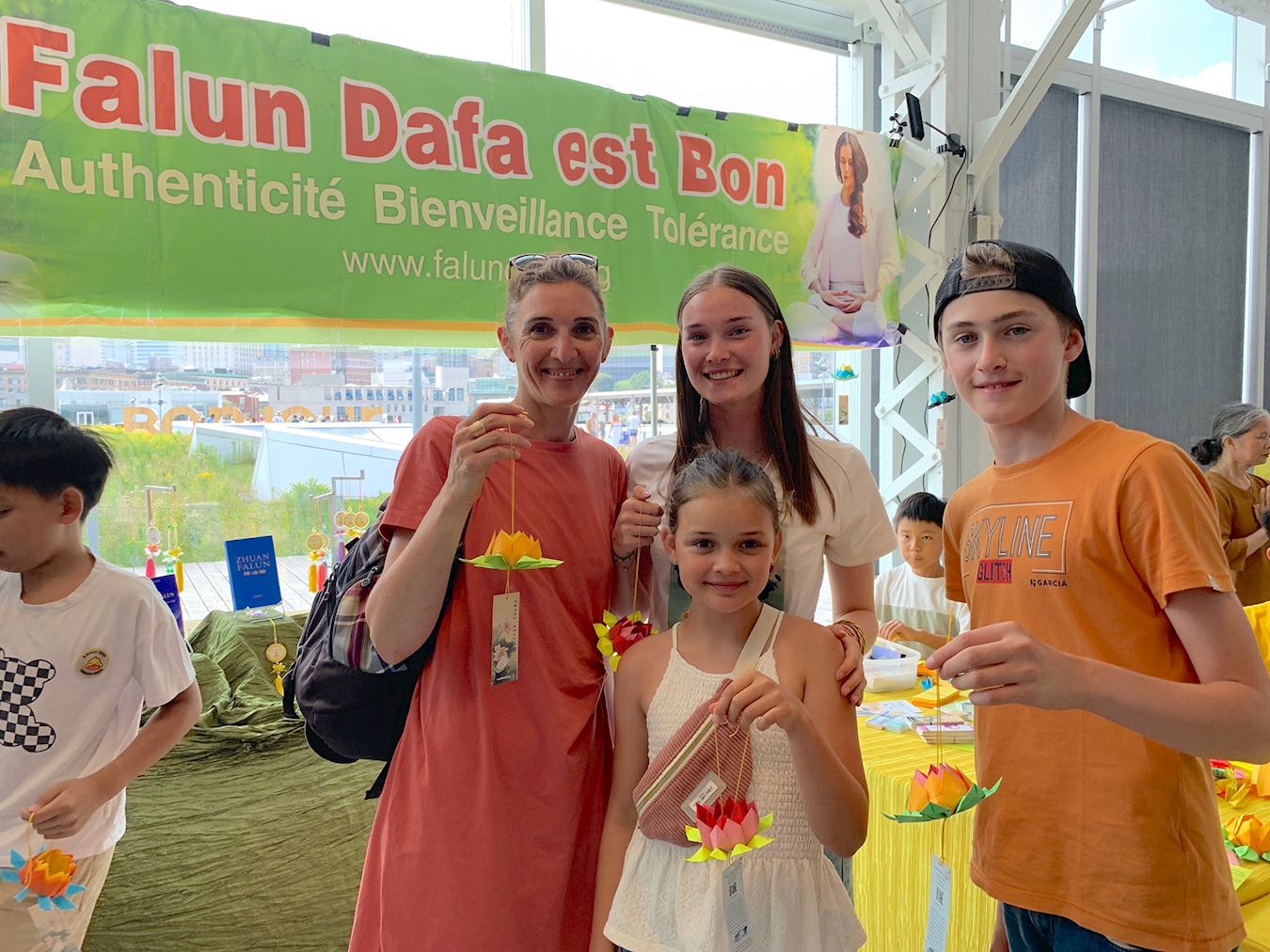 '图12:法国游客克里斯提娜(左一)和家人在展位上度过了愉快时光,她表示真、善、忍非常重要。'