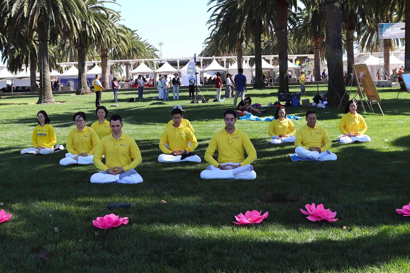 '图5~7:二零二五年十月十一日, 第24届尔湾地球村节,法轮功学员在舞台上和大公园的草坪展示五套功法。'