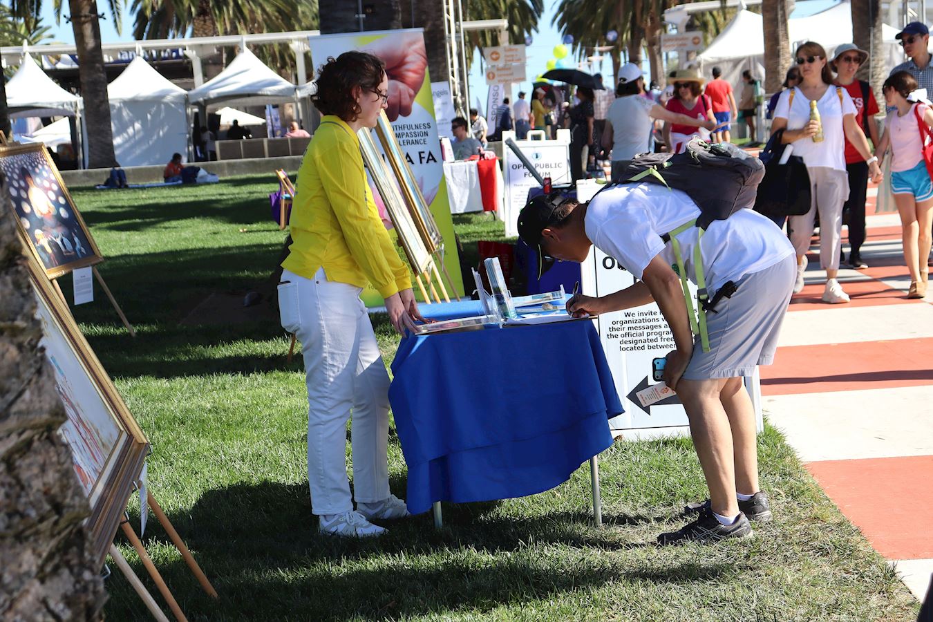 '图8~10:二零二五年十月十一日, 第24届尔湾地球村节,法轮功学员传递法轮大法的美好真相,揭露中共活摘法轮功学员器官和征集反迫害的签名。'