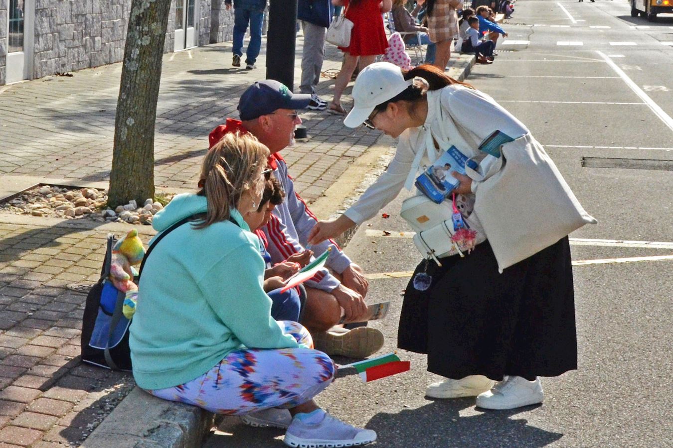 '图5~7:二零二五年十月十九日,在第三十四届海洋县哥伦布日游行期间,法轮功学员向民众发放法轮功真相资料。'