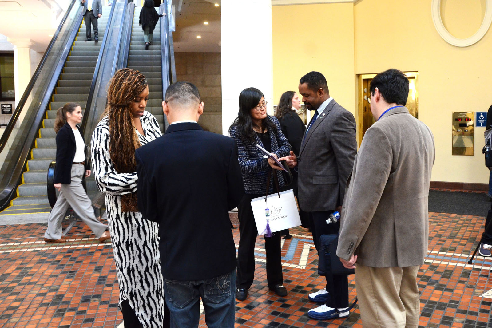 图6~10:法轮功学员在美国宾州首府哈里斯堡的州议会大厦内举行的法轮大法真相日活动中,向州政府人员讲法轮功真相。