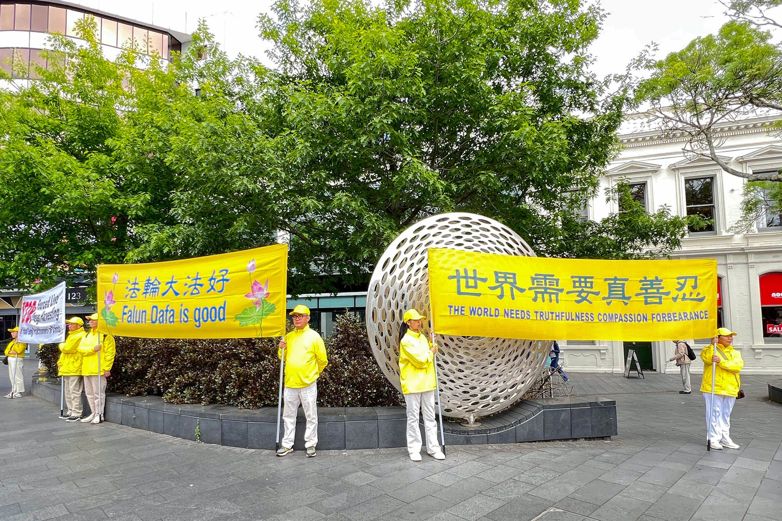 图4~5:法轮功学员在奥克兰新市场商业中心展示真相横幅。