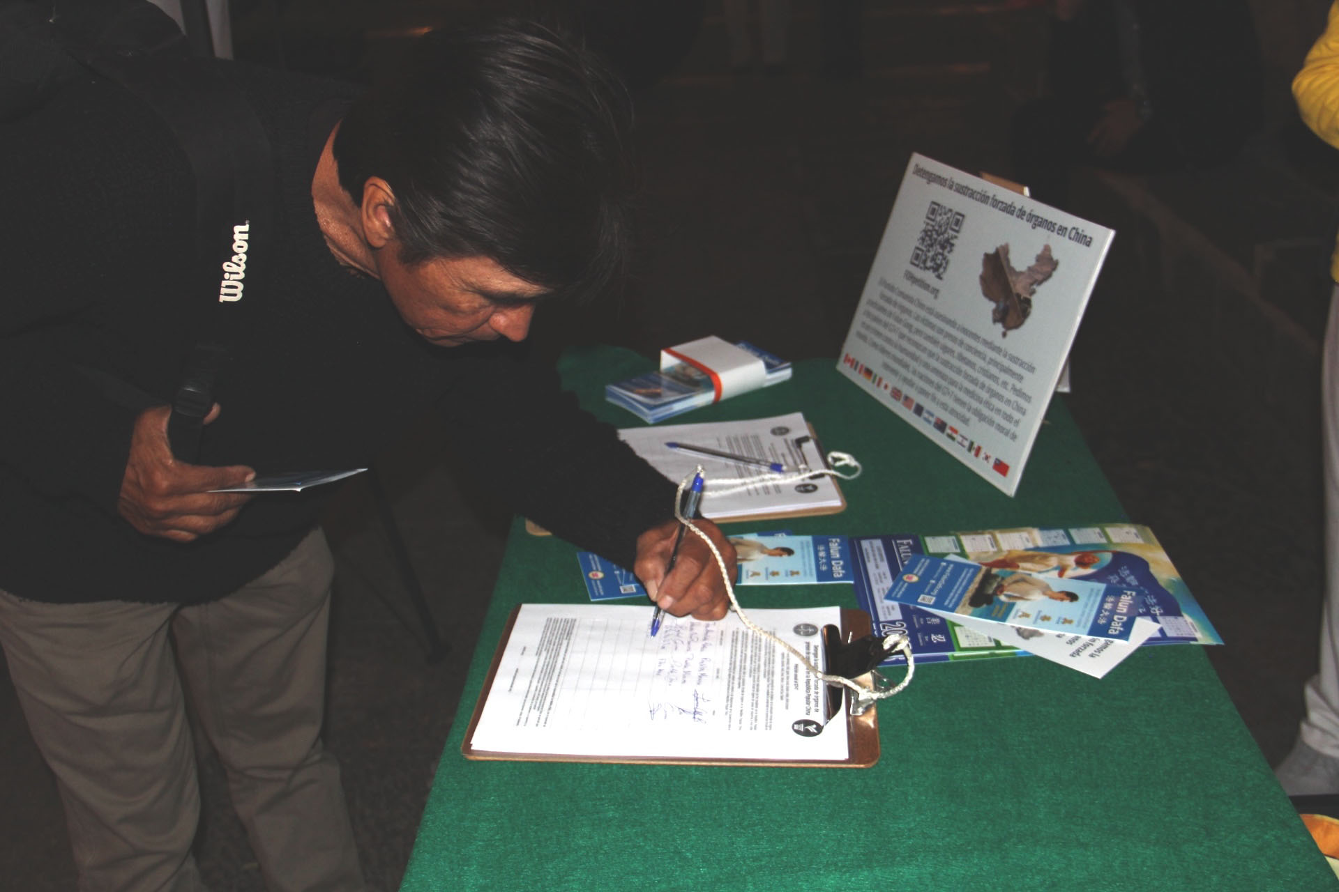 图10~11:民众在呼吁中共停止强摘法轮功学员器官的请愿书上签字。