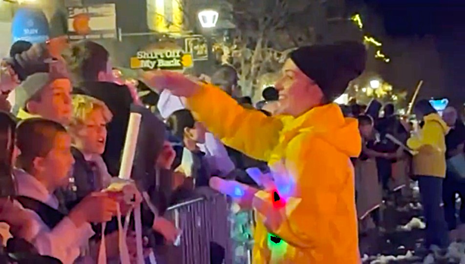 图3~4:法轮功学员及家属在游行途中向观众发放真相传单