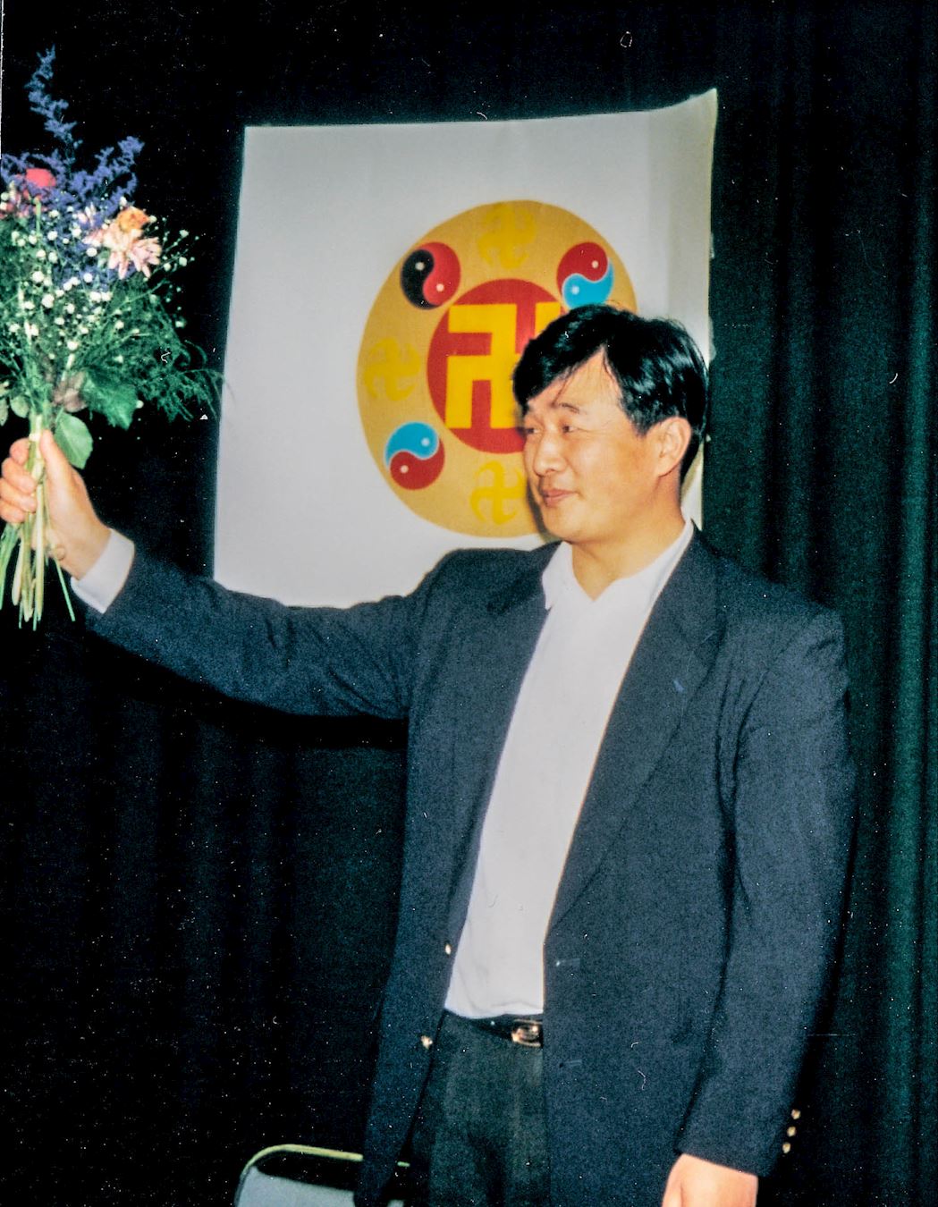 '图1:一九九五年四月李洪志师父在瑞典哥德堡举办的传功讲法班结束后,学员上台向师父献花并赠送了小纪念品,师父接过鲜花微笑向大家挥手作别。'