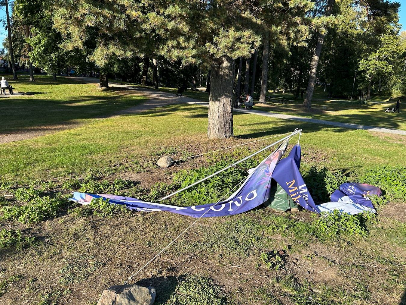 '图4:两名中国年轻人将悬挂的横幅放倒在地'