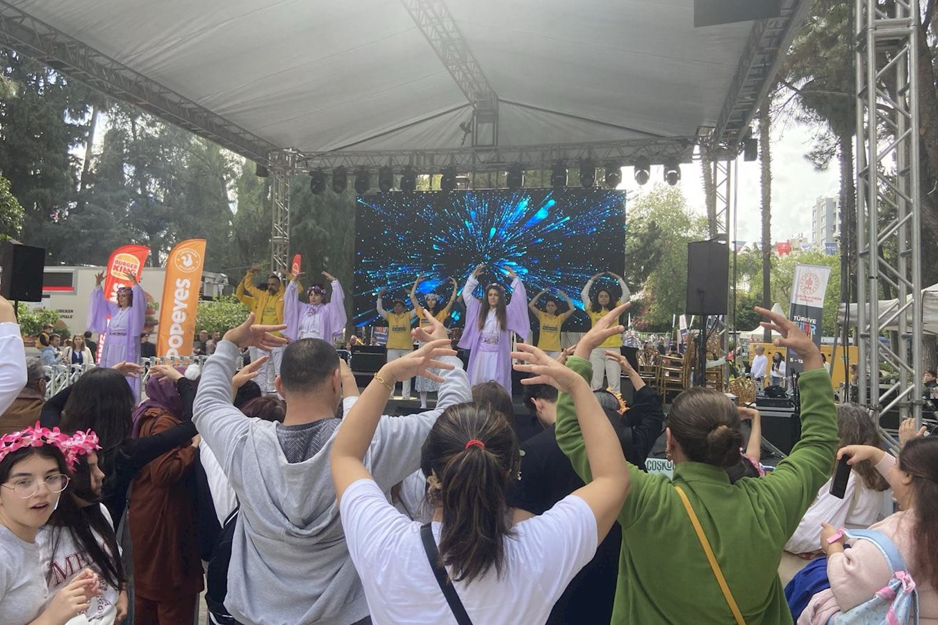 '图8:许多游客跟学员一起学炼法轮功功法。'