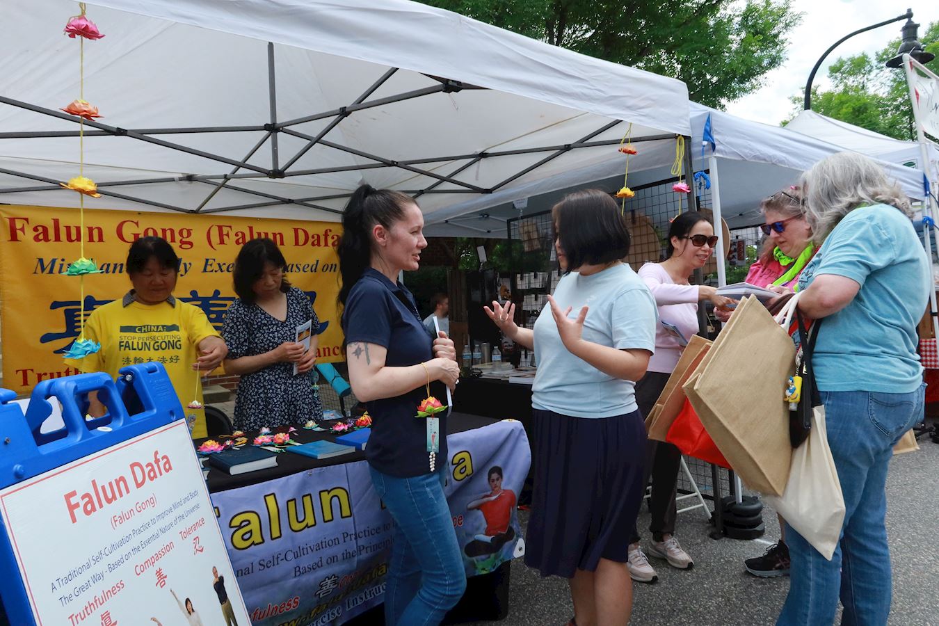 '图1~2:二零二五年五月三日,美国北卡州的法轮功学员参加了“街头相会”(Meet in the Street)艺术节,向当地民众介绍法轮大法。'