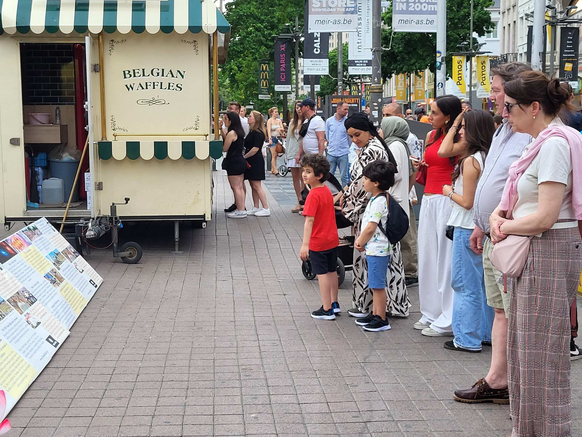 图1~3:二零二五年六月十四日,法轮功学员们在比利时安特卫普市商业中心大街上集体炼功弘法