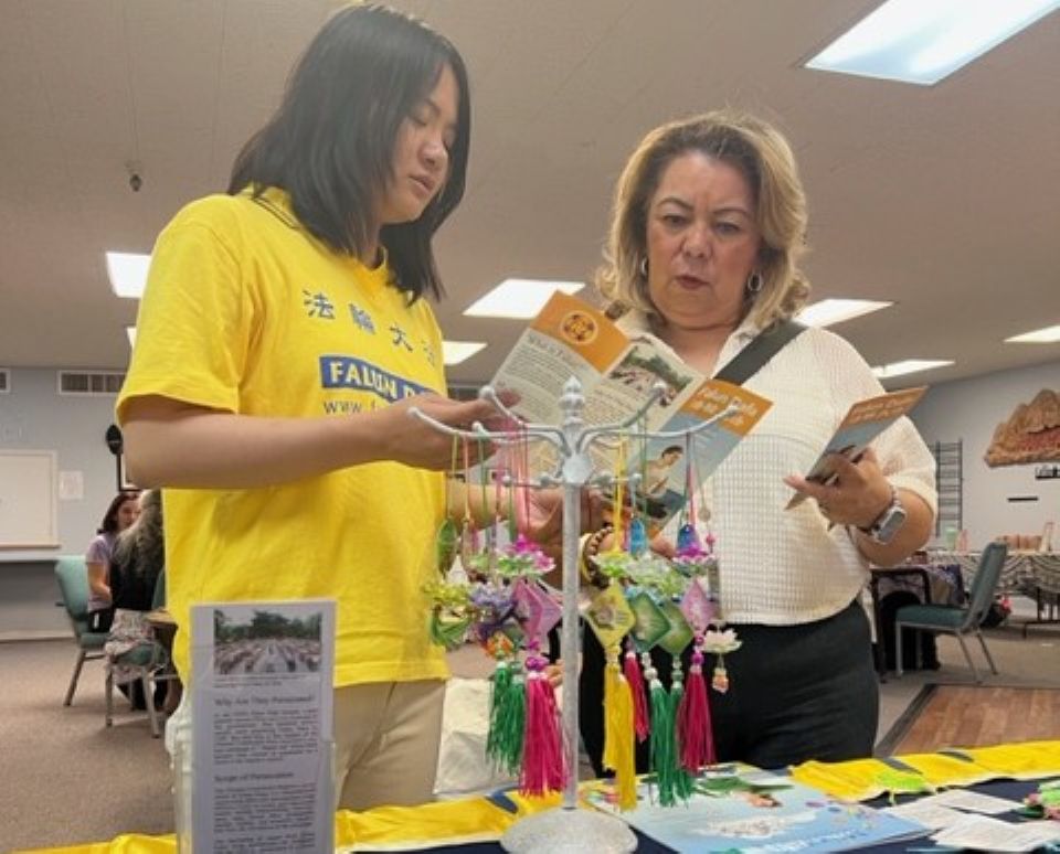 图1~2:法轮功学员在西谷健康展会上向人们介绍法轮大法的美好与揭露中共迫害法轮功的真相。