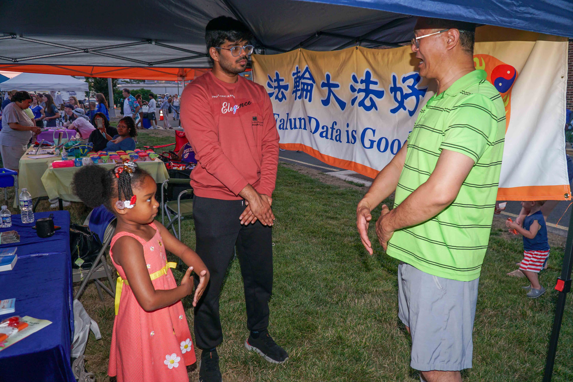 图4:七月四日,特拉华州纽瓦克市独立日庆祝活动,一位六岁的小女孩很认真地学炼着法轮功功法。