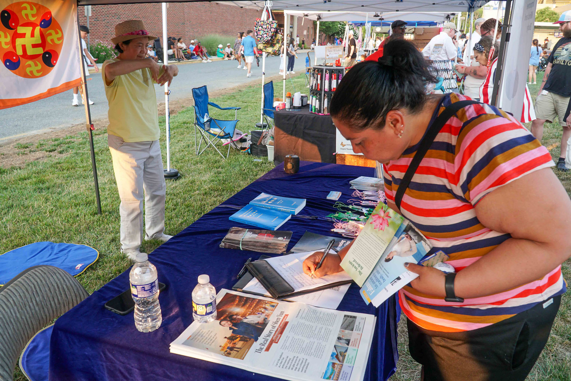 图6~9:七月四日,特拉华州纽瓦克市独立日庆祝活动中,很多人在了解到法轮功反中共迫害真相后,在美国参议院通过《法轮功保护法案》请愿书上签名支持。