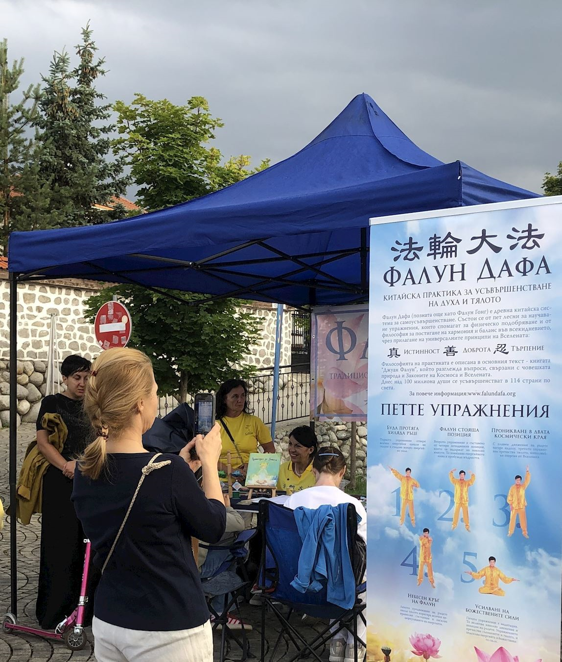 '图5~15:在班斯科中央公园,法轮功学员和游客交谈,许多民众在谴责迫害的请愿书上签名以表支持。'