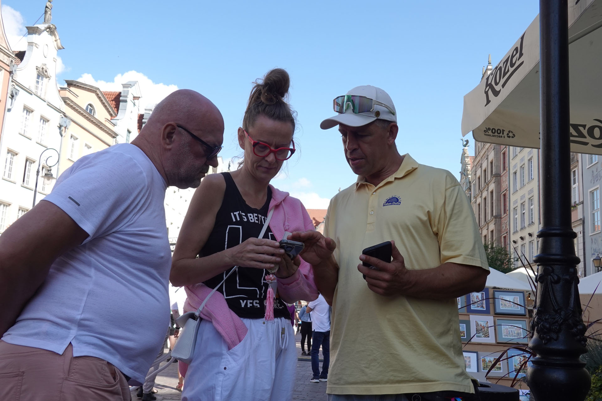 图12:贾斯蒂娜女士(中)与先生用手机观看法轮功师父的教功视频