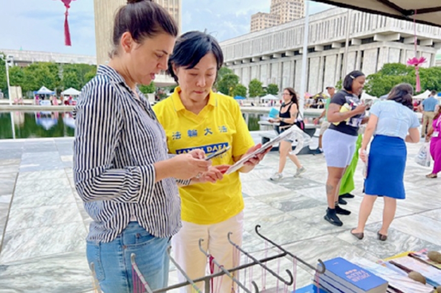 图6:法轮功学员教给政府工作人员如何用手机登陆法轮大法官方网站。