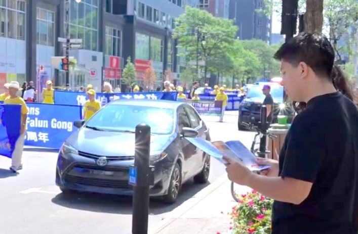 '图8:游行途中的路人在阅读“停止跨国打压”传单。'