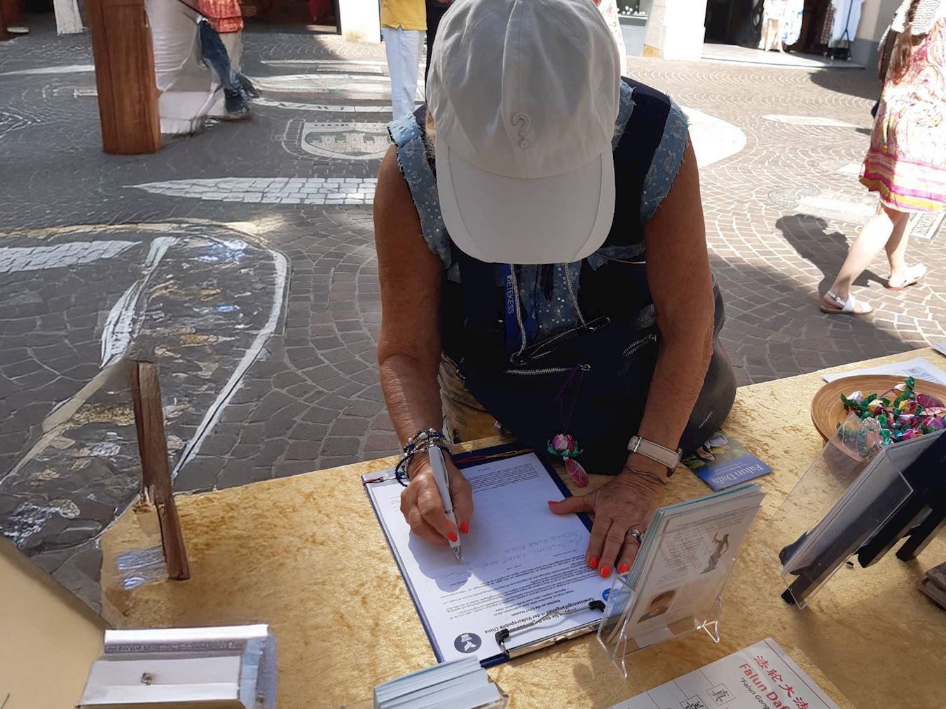 '图5~6:民众在请愿书上签名声援反迫害。'